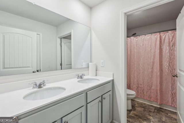 bathroom with double vanity, a sink, toilet, and a shower with curtain