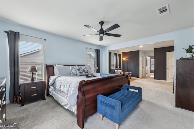 bedroom featuring light colored carpet, ceiling fan, visible vents, and baseboards