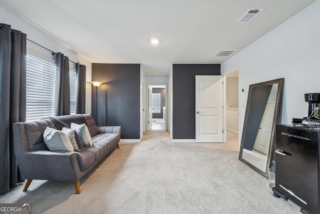 living room featuring visible vents, light carpet, and baseboards