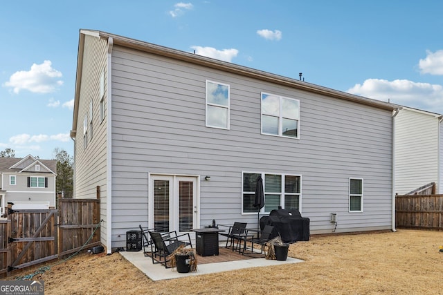 rear view of property featuring a patio area, a fenced backyard, a gate, and a lawn