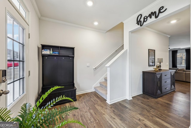 foyer with ornamental molding, dark wood finished floors, baseboards, and stairs