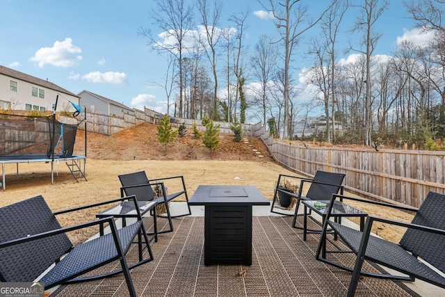 view of patio with a trampoline and a fire pit