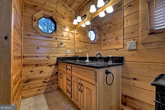 bathroom featuring vanity, tile patterned flooring, and wood walls