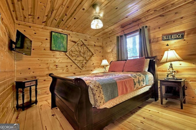 bedroom with wood-type flooring, wooden ceiling, and wooden walls