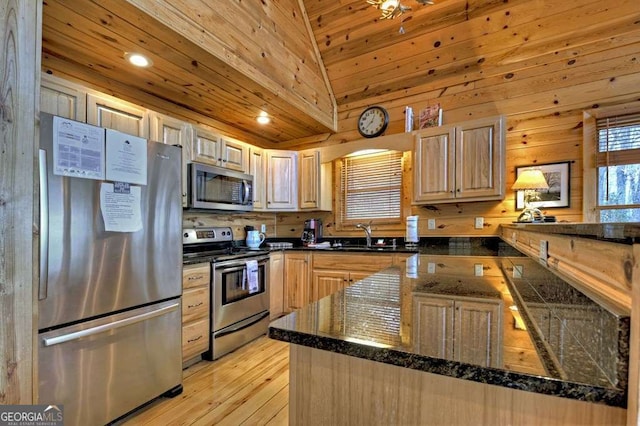 kitchen with appliances with stainless steel finishes, sink, light brown cabinets, and kitchen peninsula