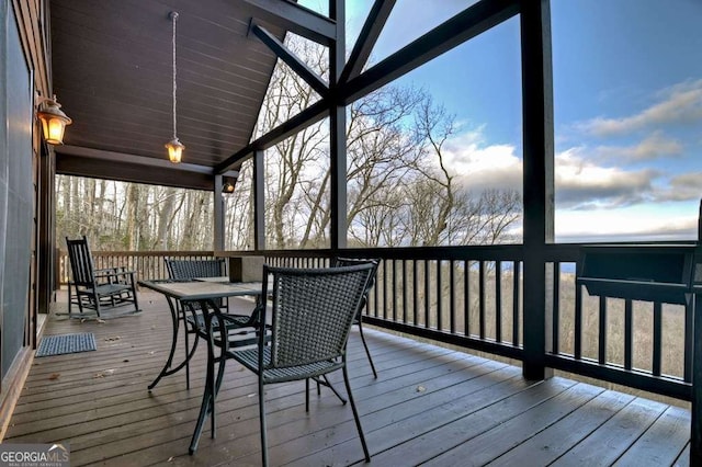 unfurnished sunroom featuring a wealth of natural light and vaulted ceiling