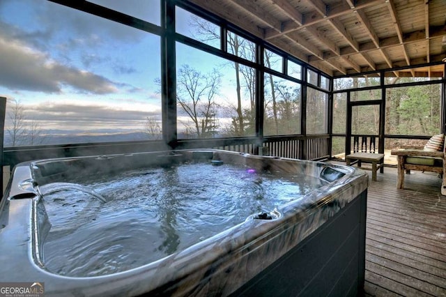 pool at dusk featuring a hot tub