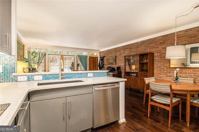 kitchen with sink, decorative light fixtures, stainless steel dishwasher, dark hardwood / wood-style floors, and backsplash