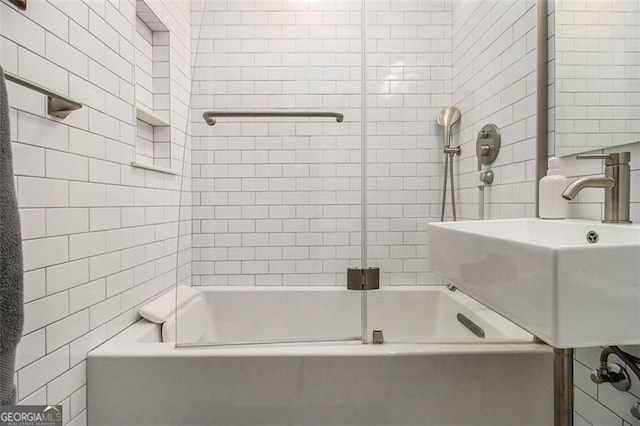 bathroom featuring tile walls, sink, and tiled shower / bath