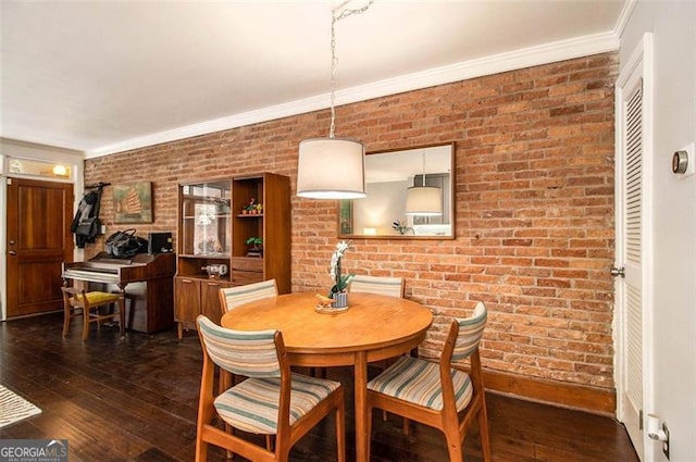 dining space with ornamental molding, brick wall, and dark hardwood / wood-style floors