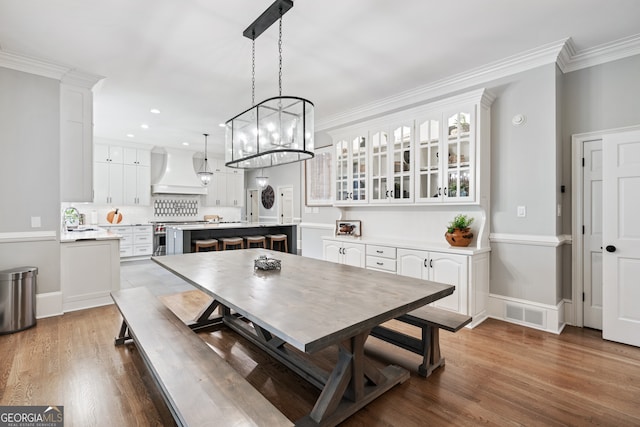 dining space featuring dark wood-type flooring, ornamental molding, and sink