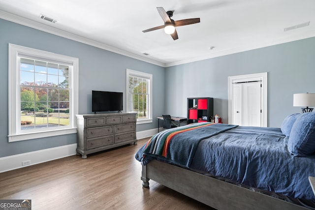 bedroom featuring wood-type flooring, ornamental molding, and ceiling fan