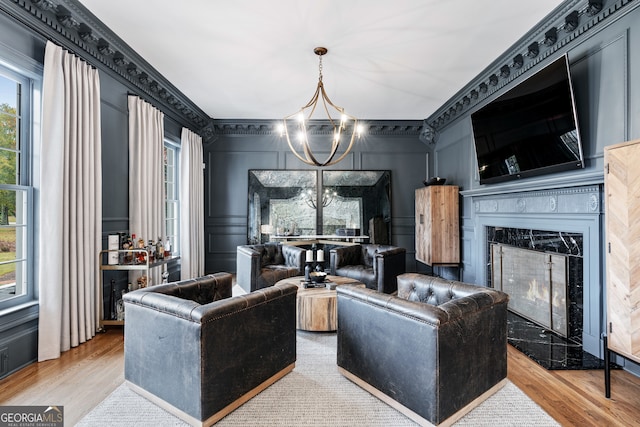 living room featuring a fireplace, a chandelier, and light hardwood / wood-style floors