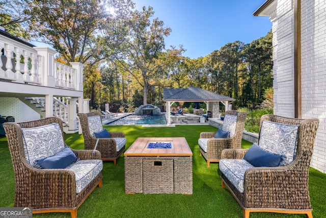 exterior space with a gazebo, pool water feature, an outdoor fire pit, and a pool side deck