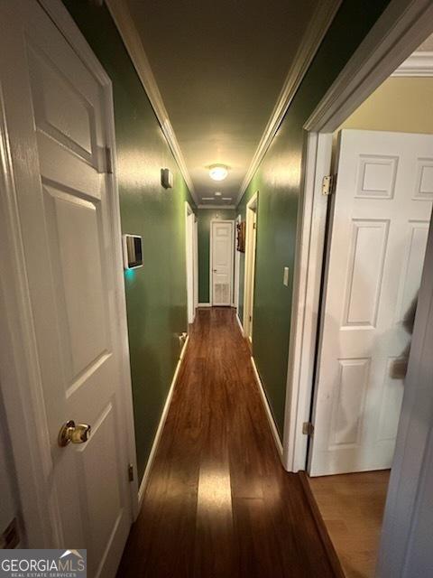 hall with ornamental molding and dark hardwood / wood-style flooring