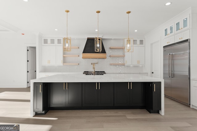 kitchen featuring white cabinets, custom exhaust hood, stainless steel appliances, and a spacious island