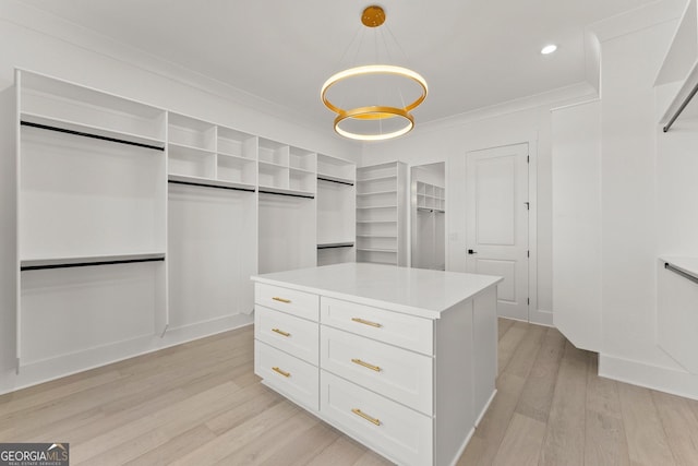 spacious closet featuring a chandelier and light wood-type flooring