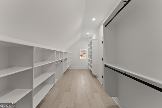 spacious closet featuring light hardwood / wood-style flooring and vaulted ceiling