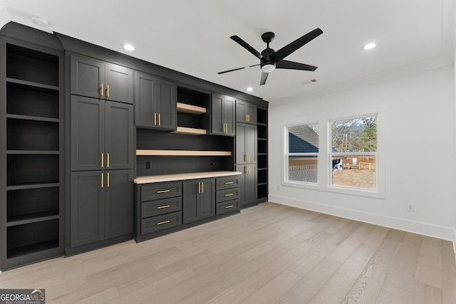 interior space with ornamental molding, ceiling fan, and light hardwood / wood-style floors