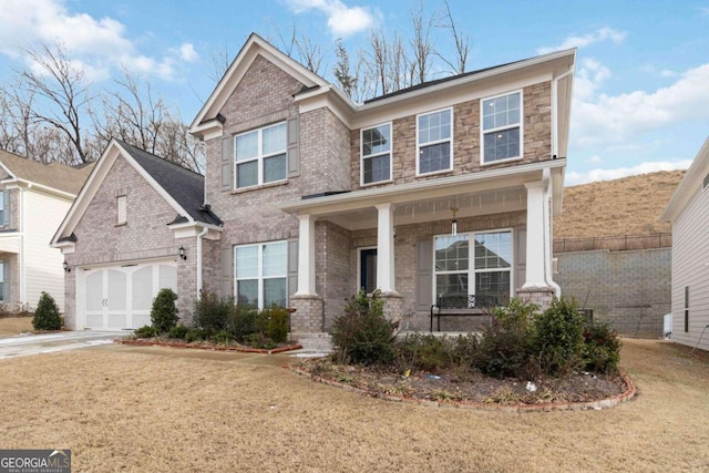 view of front of home featuring a garage, a front yard, and covered porch