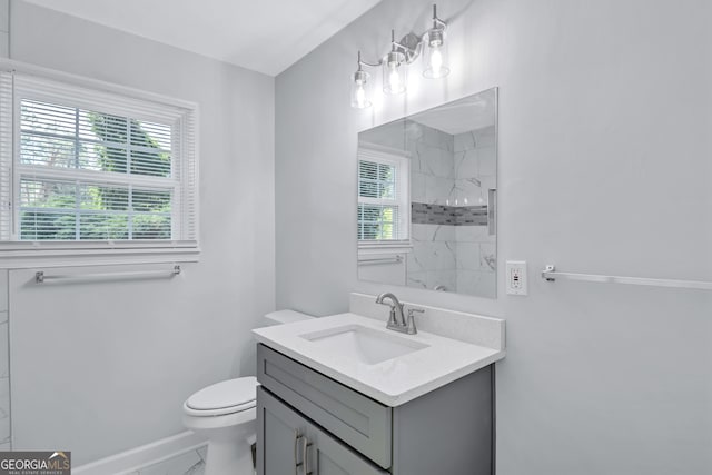 bathroom with vanity, a tile shower, and toilet