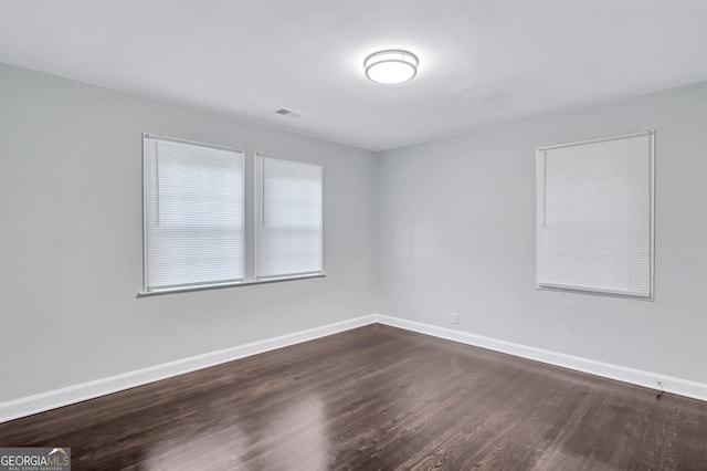 unfurnished room with dark wood-type flooring