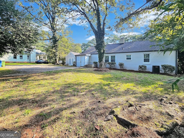 view of front of property with central AC and a front yard