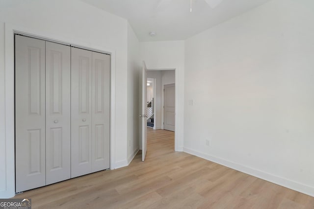 unfurnished bedroom with a closet and light wood-type flooring