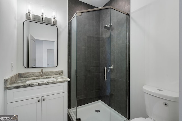 bathroom featuring vanity, toilet, and walk in shower