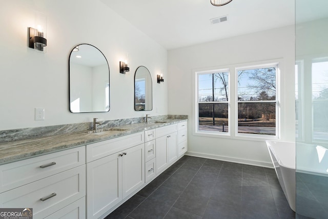 bathroom featuring tile patterned flooring, vanity, and a bathtub