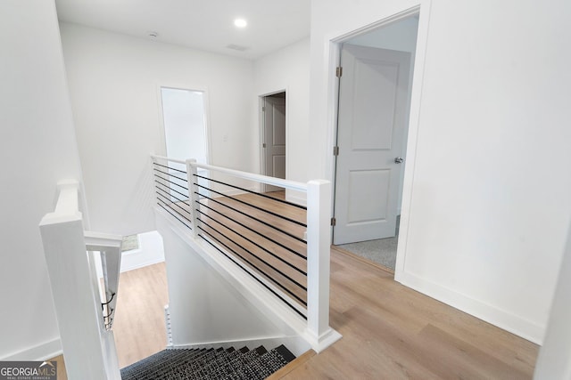 stairway with hardwood / wood-style floors