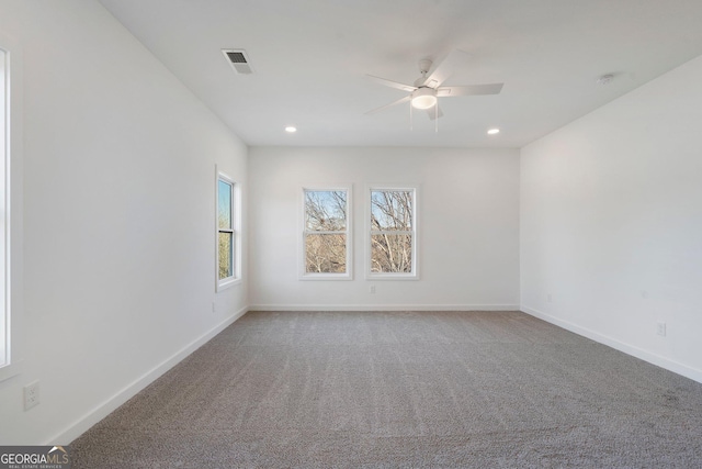 carpeted spare room featuring ceiling fan