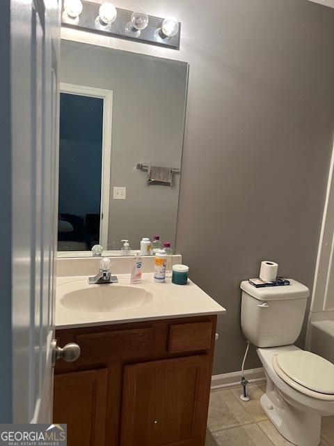 bathroom with toilet, tile patterned flooring, and vanity