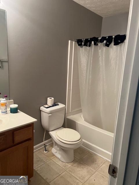 full bathroom featuring vanity, a textured ceiling, toilet, tile patterned floors, and shower / tub combo with curtain