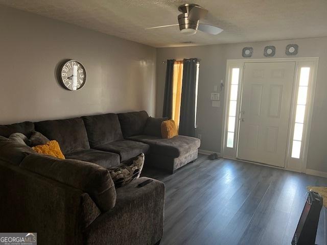 living room with a textured ceiling, hardwood / wood-style floors, and ceiling fan