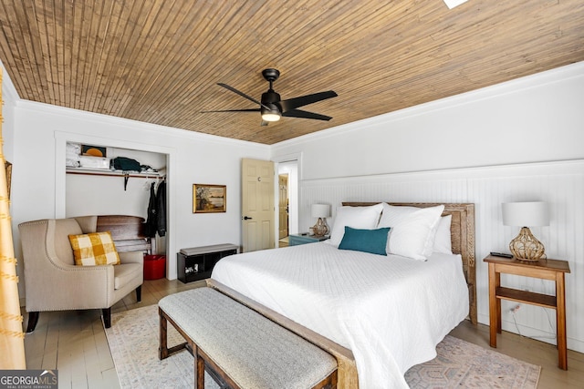 bedroom with a closet, wood ceiling, ornamental molding, and light hardwood / wood-style floors