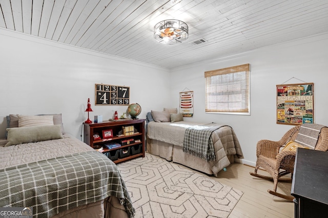 bedroom with crown molding, light hardwood / wood-style flooring, and wooden ceiling