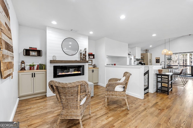 living room with vaulted ceiling and light wood-type flooring