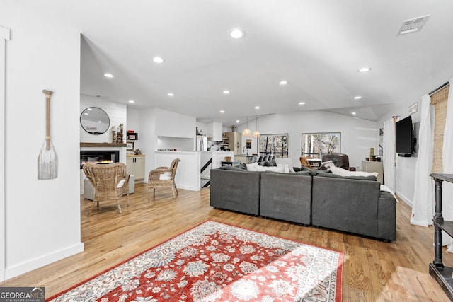 living room featuring lofted ceiling and light wood-type flooring