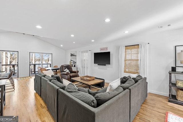 living room with vaulted ceiling and light hardwood / wood-style flooring