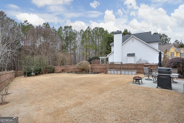 view of yard with an outdoor fire pit and a patio