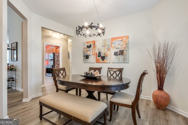 dining space with a chandelier and light hardwood / wood-style floors