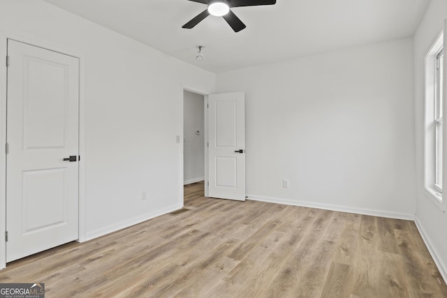 unfurnished bedroom featuring multiple windows, ceiling fan, and light hardwood / wood-style flooring