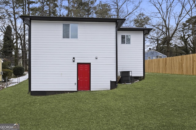 rear view of property with a yard and central air condition unit