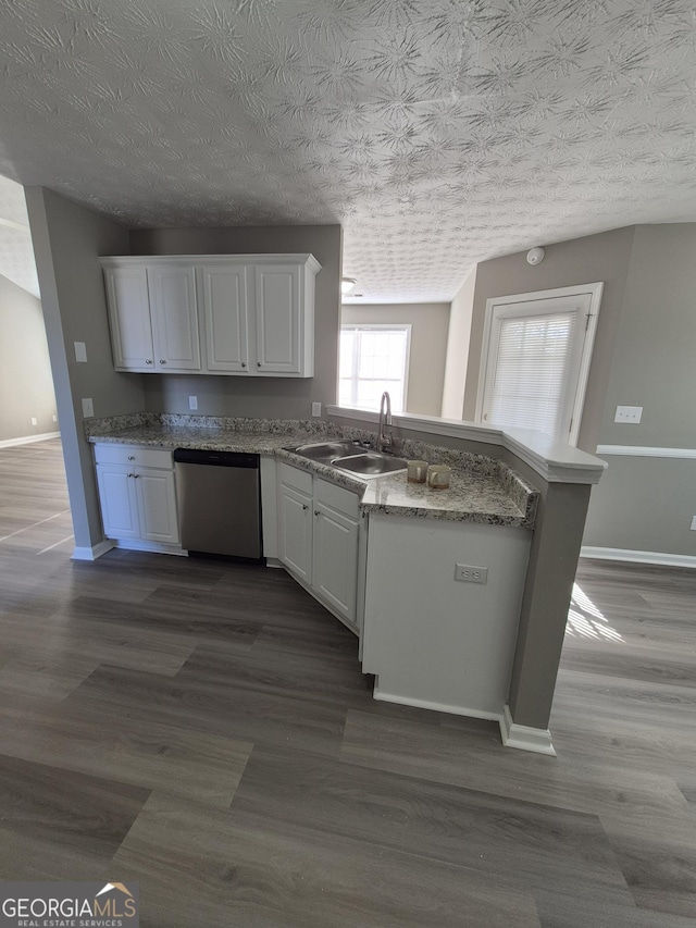 kitchen with white cabinetry, sink, stainless steel dishwasher, and a textured ceiling