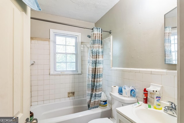 full bathroom featuring shower / tub combo, tile walls, vanity, a textured ceiling, and toilet