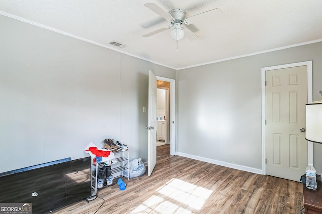 interior space with crown molding, ceiling fan, hardwood / wood-style floors, and a textured ceiling