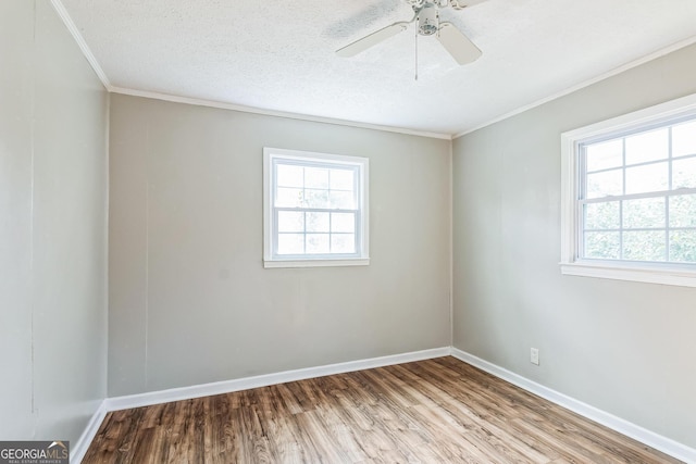 spare room featuring crown molding, ceiling fan, a healthy amount of sunlight, and light wood-type flooring