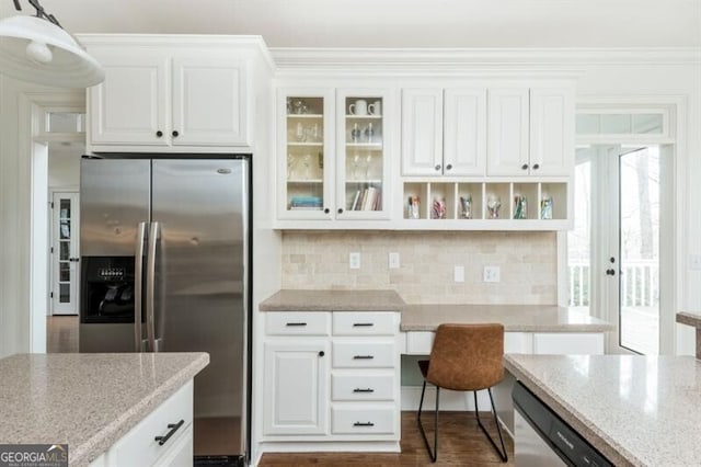 kitchen with appliances with stainless steel finishes, pendant lighting, white cabinetry, decorative backsplash, and light stone counters