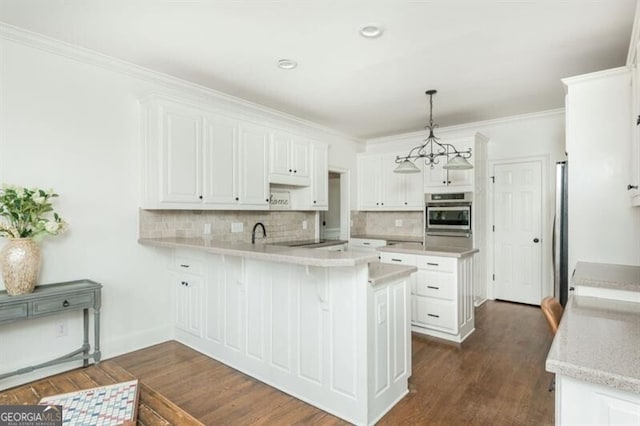 kitchen featuring decorative light fixtures, appliances with stainless steel finishes, kitchen peninsula, white cabinets, and backsplash